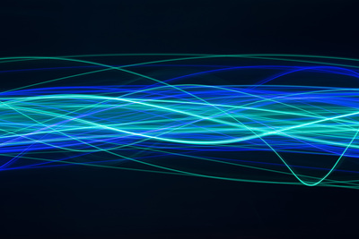 a complicated waveform pattern created from cyan and blue random and overlapping waves of light